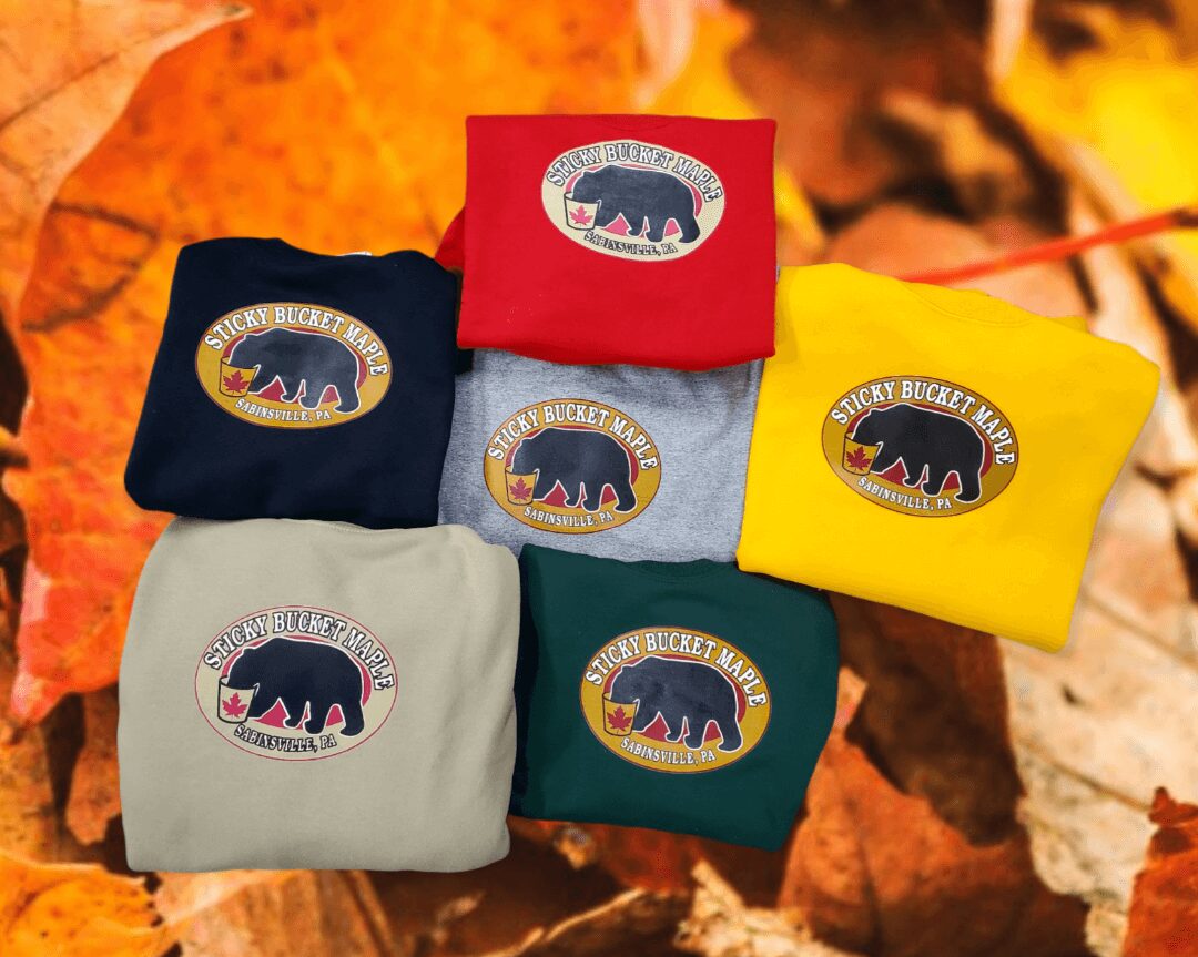 Different colored T-shirts with Sticky Bucket Maple logos